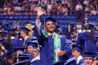 Student waving at Commencement