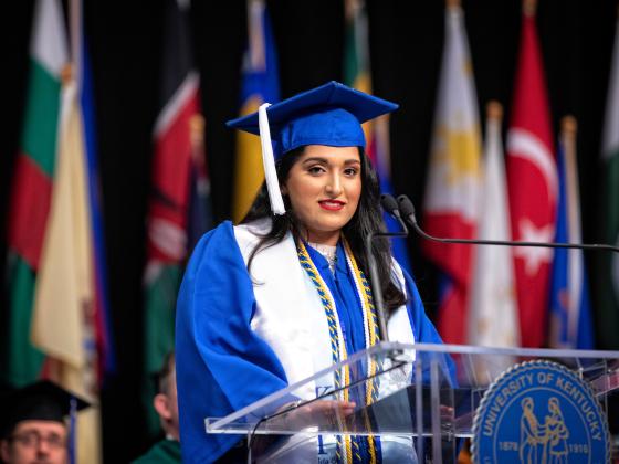 Students speaks on stage at graduation